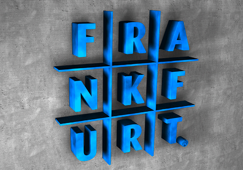 Das Bild zeigt das Logo des Labels „FRA-NKF-URT“. Blaue Buchstaben auf einer Beton-Wand.